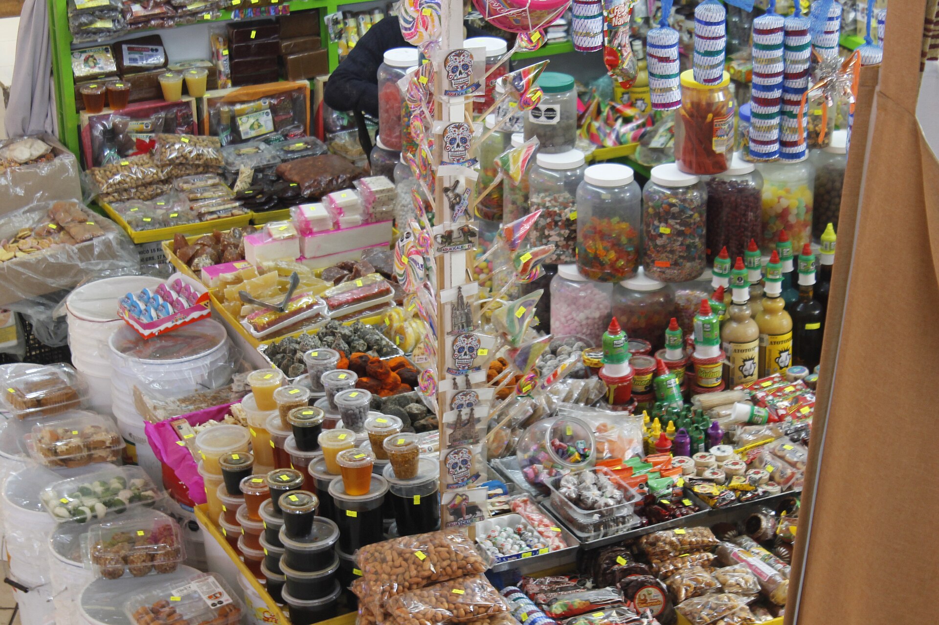 Puesto de dulces típicos mexicanos con frascos y paletas